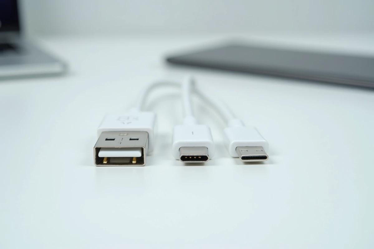 Vue de dessus de connecteurs USB Type-A, Type-C et micro-USB alignés sur une surface blanche pour illustrer leurs différences