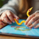 Mains d'enfant tenant un serpent en origami sur une tablette