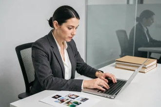 Femme professionnelle protégeant des images sensibles sur ordinateur dans un bureau sécurisé